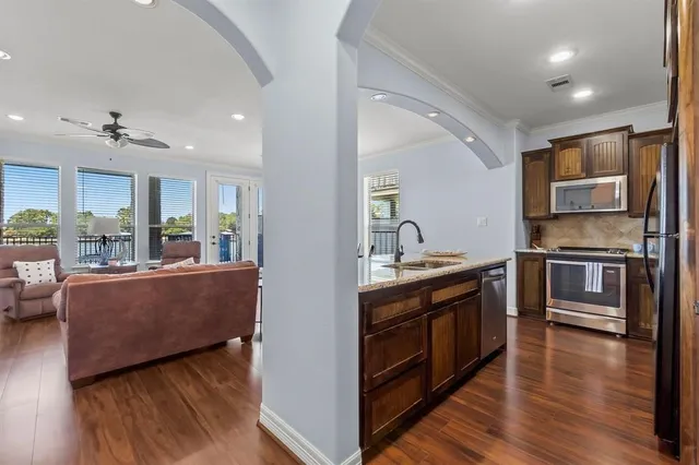 a large kitchen with stainless steel appliances granite countertop a lot of counter space and wooden floors
