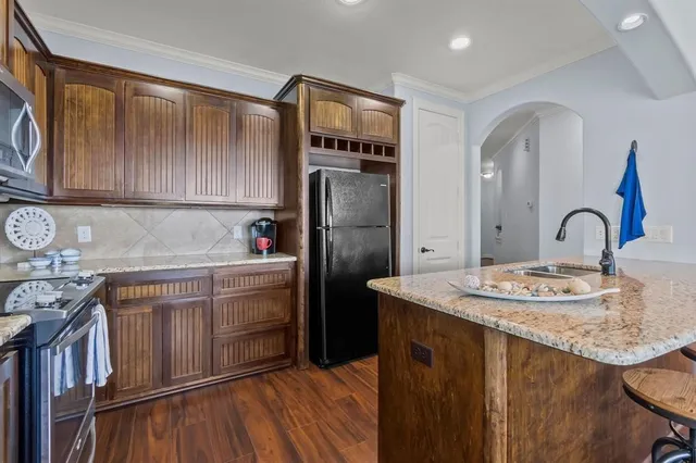 a kitchen with stainless steel appliances granite countertop a sink stove and refrigerator