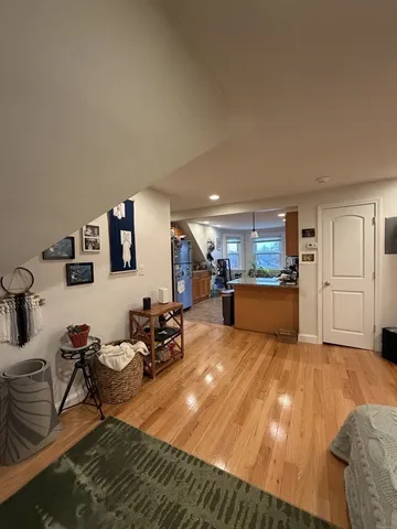 a living room with furniture kitchen view and a wooden floor
