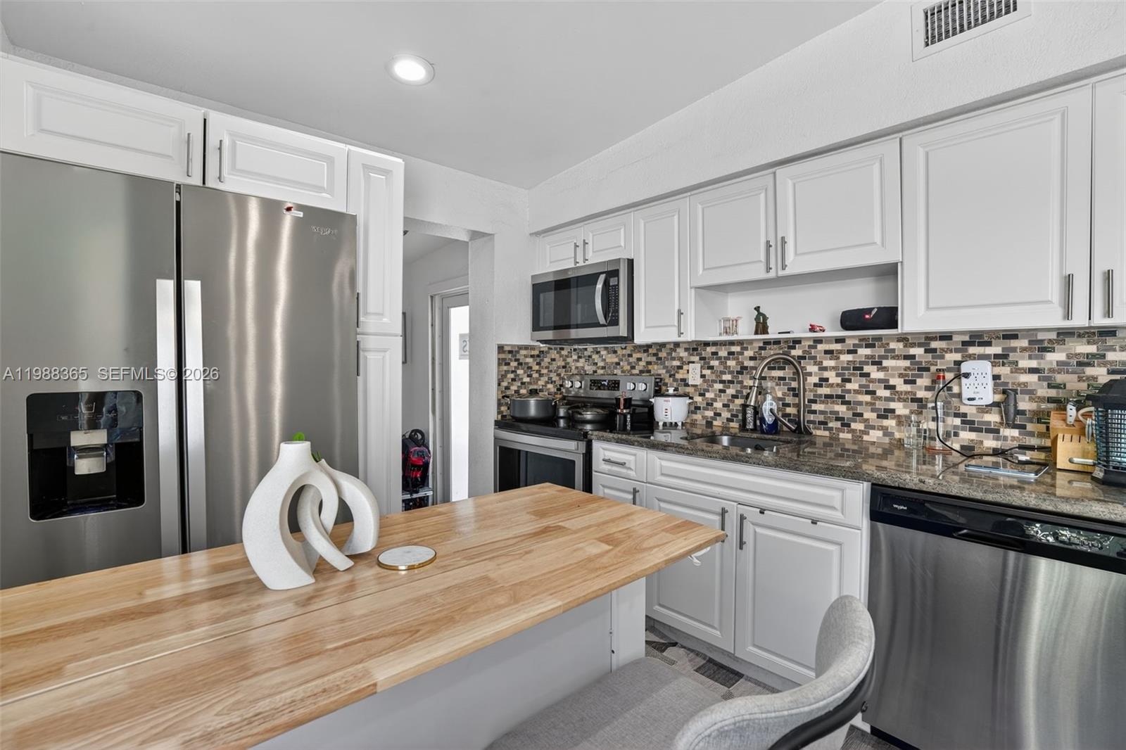 2001 Rutland Street Opa-Locka, FL 33054 - Photo 14 of 29 a kitchen with granite countertop a refrigerator and a stove top oven