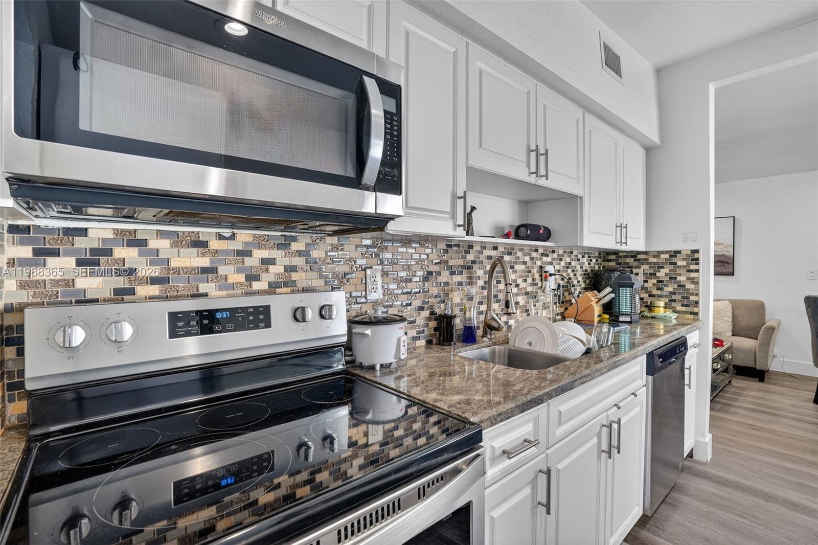 2001 Rutland Street Opa-Locka, FL 33054 - Photo 15 of 29 a kitchen with stainless steel appliances granite countertop a stove and a microwave