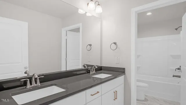 a bathroom with a granite countertop sink a large mirror and a bathtub