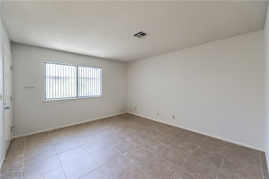 5829 Smoke Ranch Road, Unit C Las Vegas, NV 89108 - Photo 14 of 25 Empty room with light tile patterned flooring and