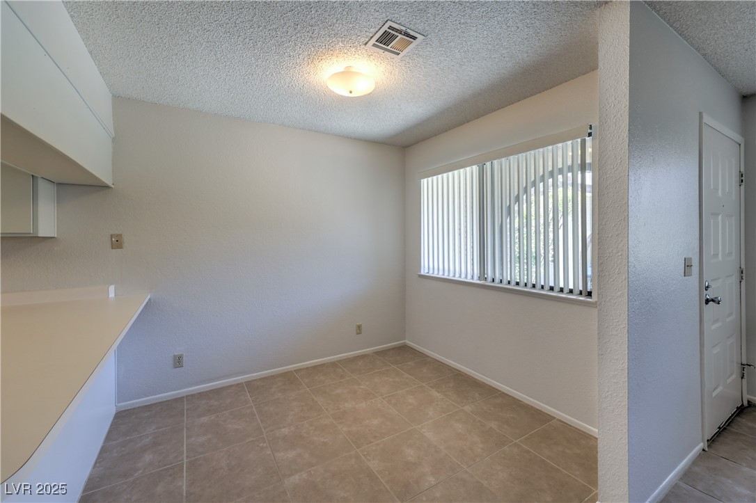 5829 Smoke Ranch Road, Unit C Las Vegas, NV 89108 - Photo 15 of 25 Unfurnished dining area featuring a textured ceili