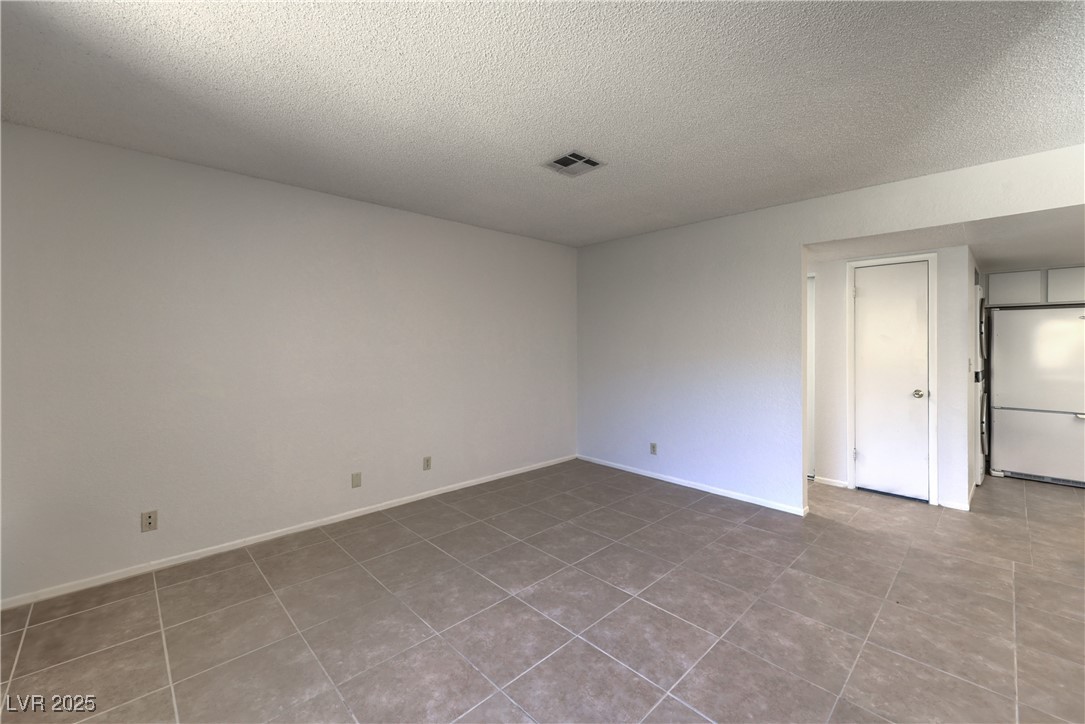 5829 Smoke Ranch Road, Unit C Las Vegas, NV 89108 - Photo 16 of 25 Unfurnished room with a textured ceiling and tile