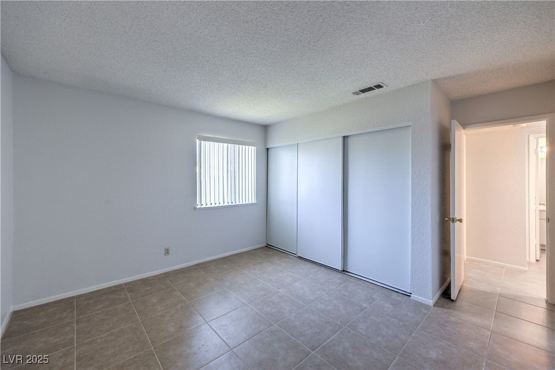 5829 Smoke Ranch Road, Unit C Las Vegas, NV 89108 - Photo 20 of 25 Unfurnished bedroom featuring a textured ceiling,
