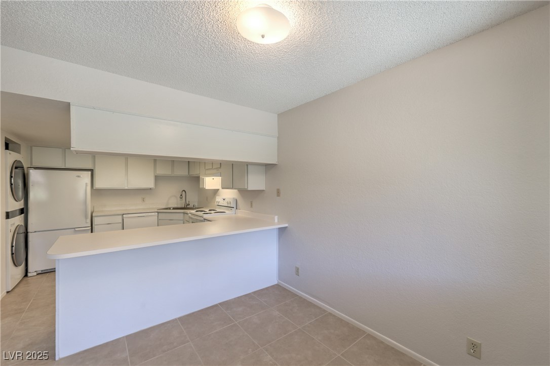 5829 Smoke Ranch Road, Unit C Las Vegas, NV 89108 - Photo 5 of 25 Kitchen featuring stacked washer and clothes dryer