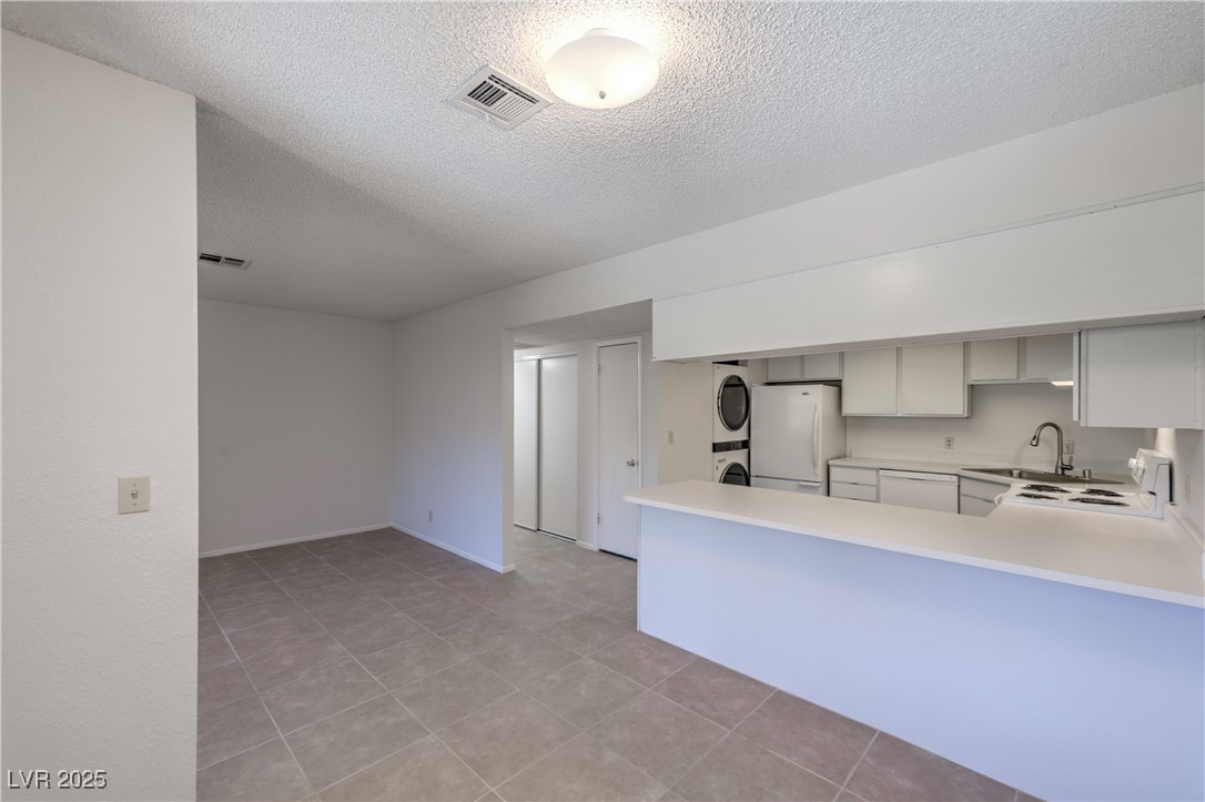 5829 Smoke Ranch Road, Unit C Las Vegas, NV 89108 - Photo 6 of 25 Kitchen with stacked washer / dryer, light counter