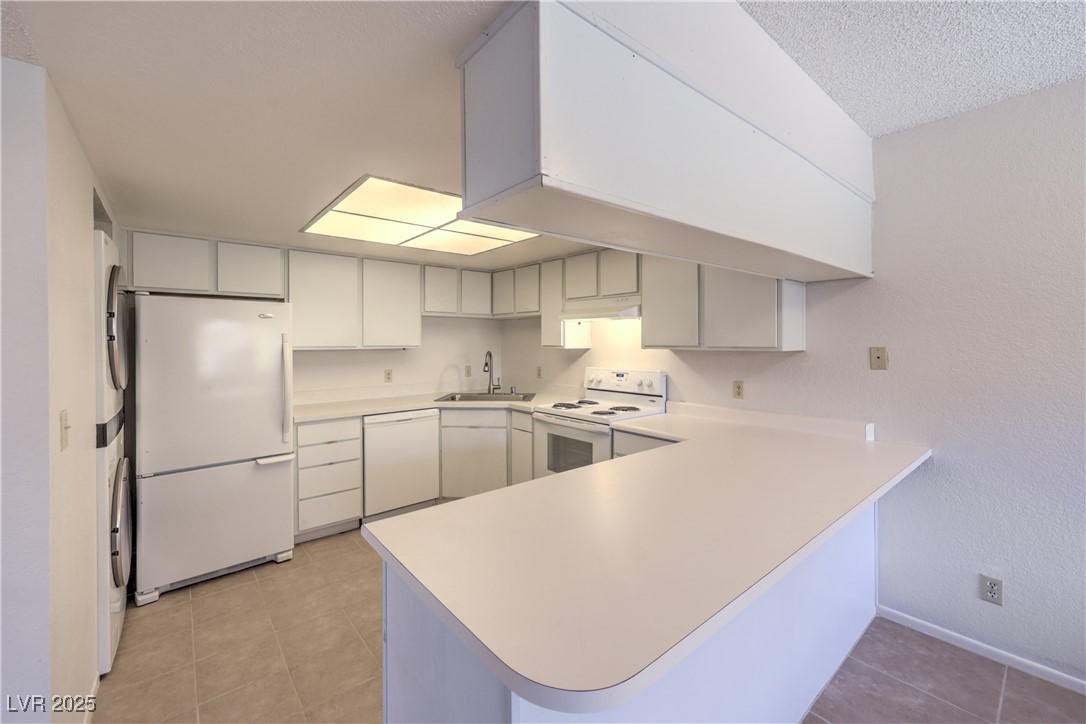 5829 Smoke Ranch Road, Unit C Las Vegas, NV 89108 - Photo 7 of 25 Kitchen with white appliances, a peninsula, light