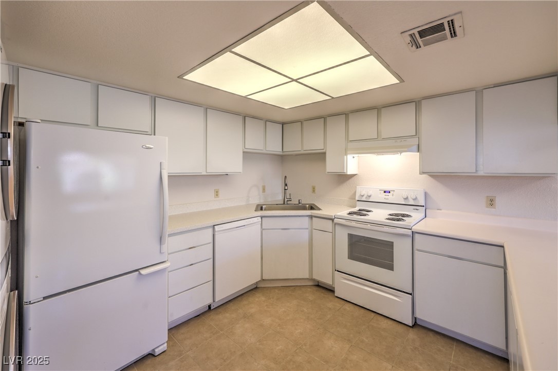 5829 Smoke Ranch Road, Unit C Las Vegas, NV 89108 - Photo 9 of 25 Kitchen featuring white appliances, light countert