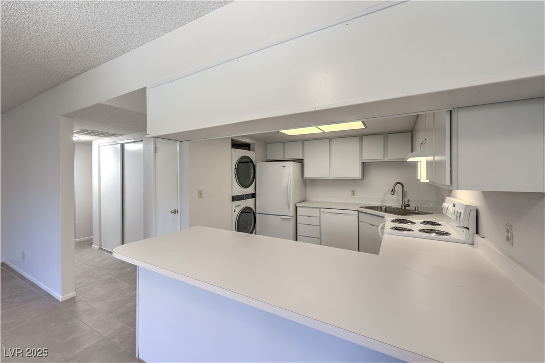 5829 Smoke Ranch Road, Unit C Las Vegas, NV 89108 - Photo 10 of 25 Kitchen featuring stacked washer / drying machine,
