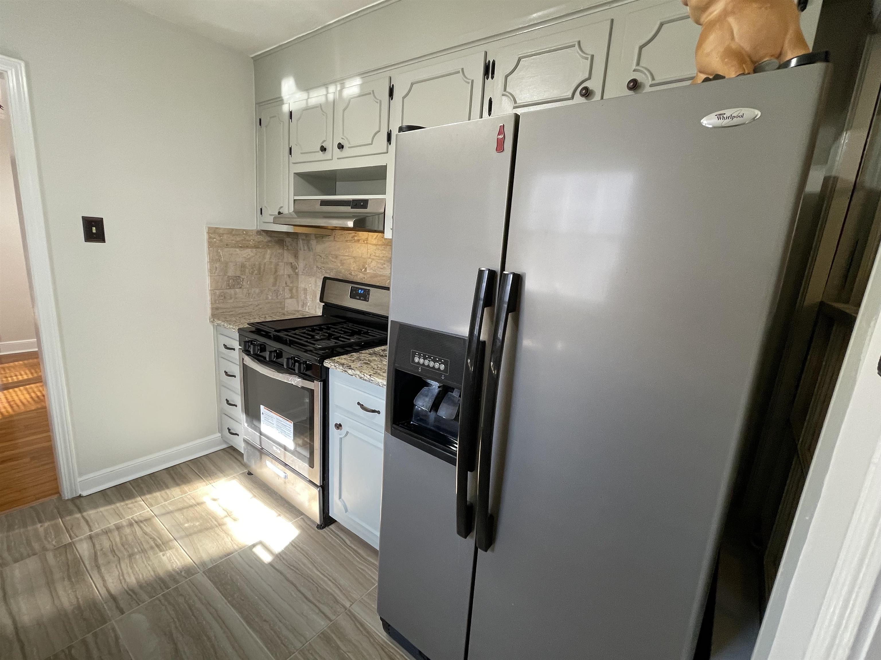 1020 Sandra Street Memphis, TN 38122 - Photo 12 of 40 a kitchen with a refrigerator a stove and wooden floor