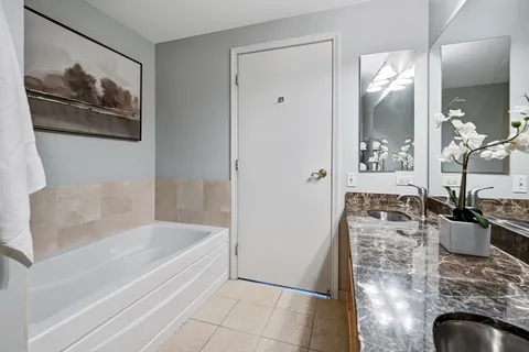 a bathroom with a granite countertop sink a bathtub and shower