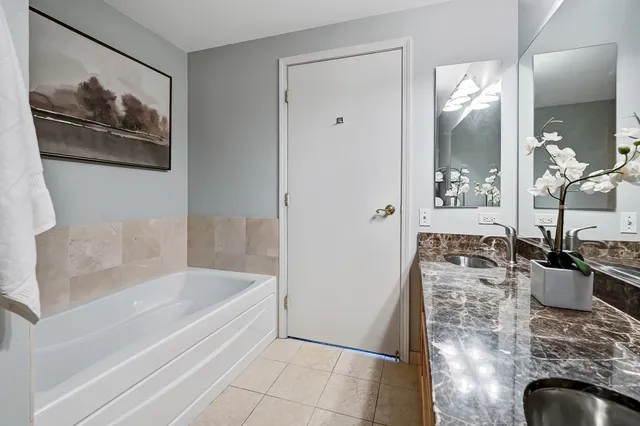 a bathroom with a granite countertop sink a bathtub and shower