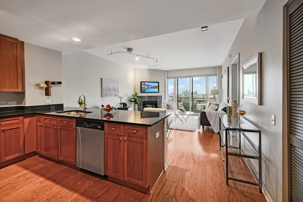 a kitchen with granite countertop a table chairs stove and wooden floor