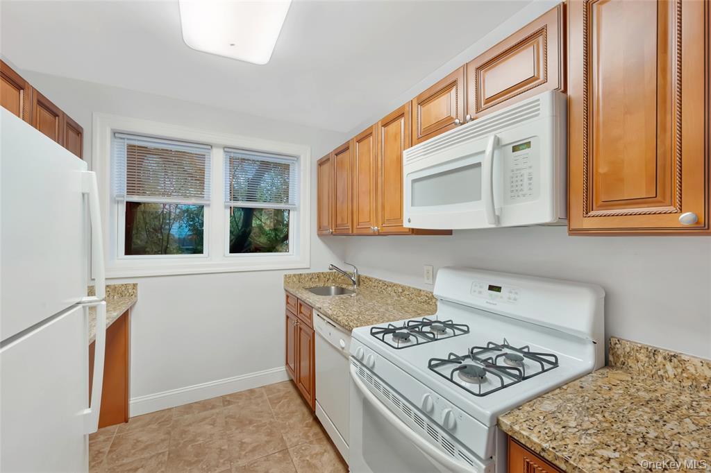 504 Pelham Road New Rochelle, NY 10805 - Photo 10 of 26 a kitchen with a stove a sink and a refrigerator