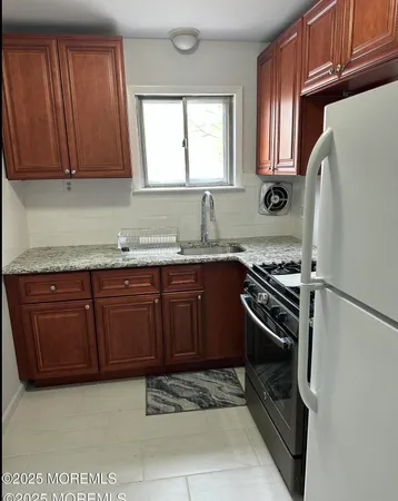a kitchen with stainless steel appliances granite countertop a stove a sink and a refrigerator