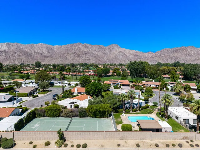 a view of a swimming pool with a lawn chairs under an umbrella