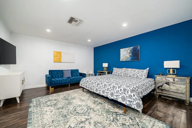 a bedroom with a bed and a flat screen tv