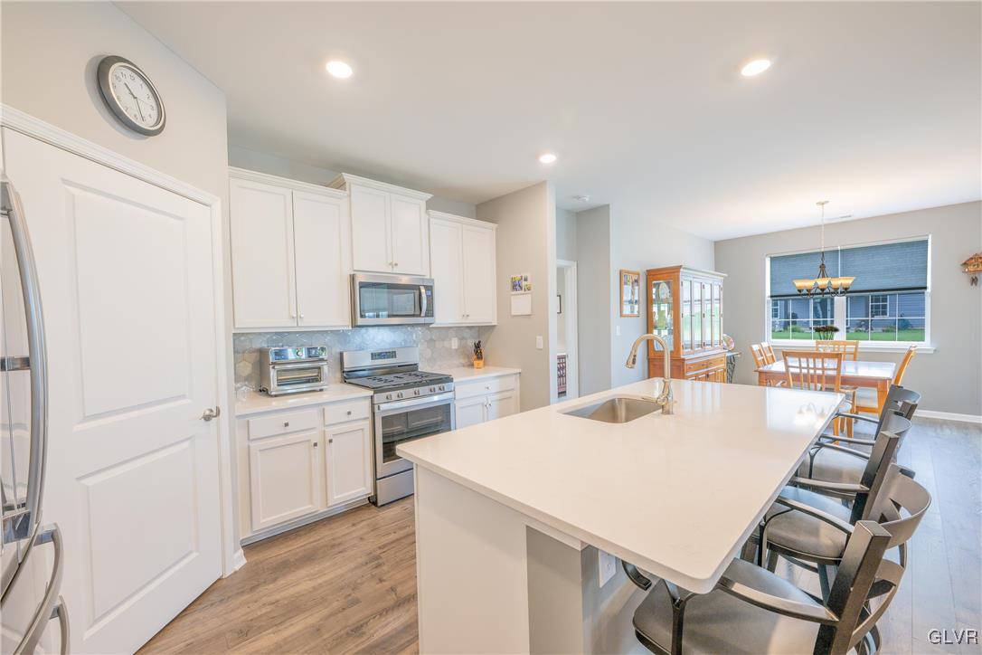 8078 Schaefer Crest Breinigsville, PA 18031 - Photo 14 of 35 a kitchen with a table chairs refrigerator and cabinets