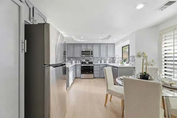 a kitchen with stainless steel appliances granite countertop a refrigerator and a stove top oven