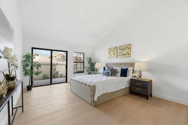 a bedroom with a bed and large windows