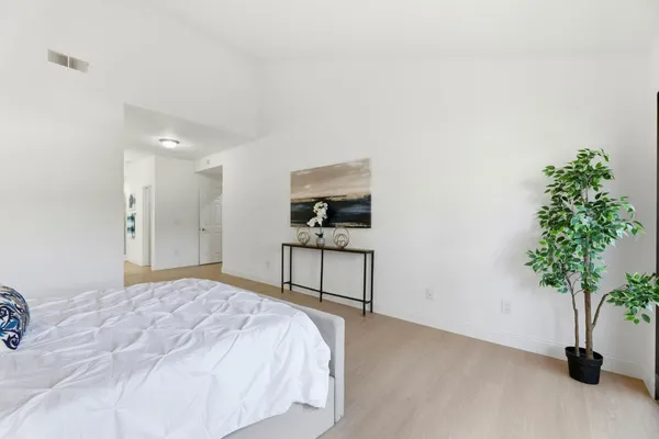a bedroom with a bed and a plant