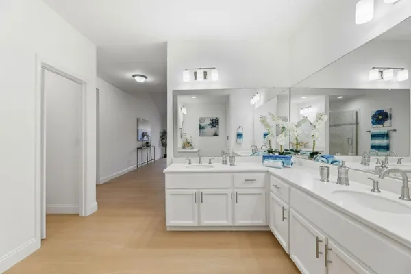a spacious bathroom with a double vanity sink a mirror and a bathtub