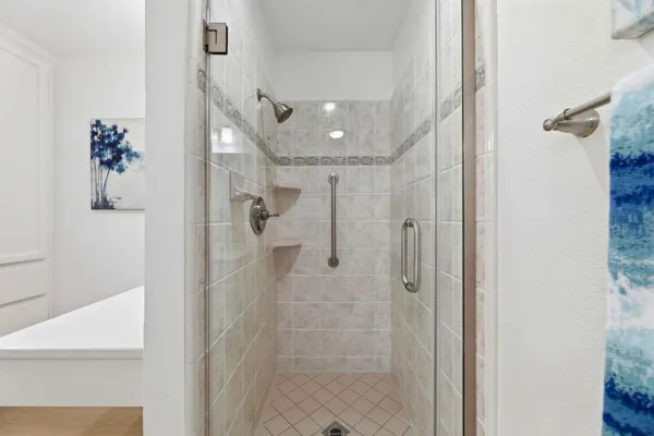 a bathroom with a shower and a glass door
