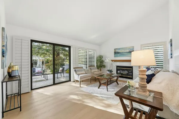 a living room with furniture a floor to ceiling window and a flat screen tv