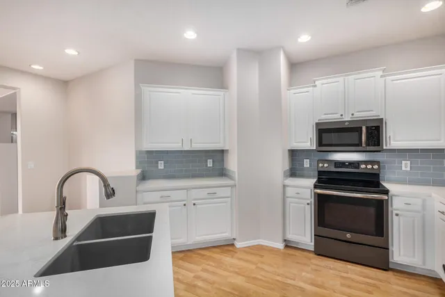 a kitchen with stainless steel appliances a stove sink and microwave