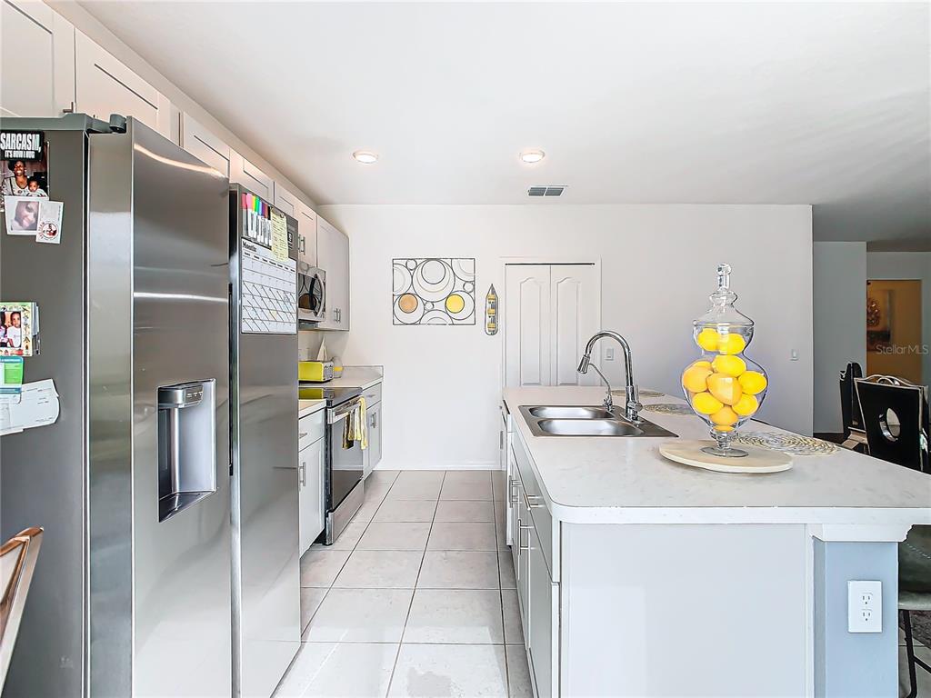 208 Goldenrod Lane Kissimmee, FL 34759 - Photo 13 of 40 a kitchen with a sink a refrigerator and a stove