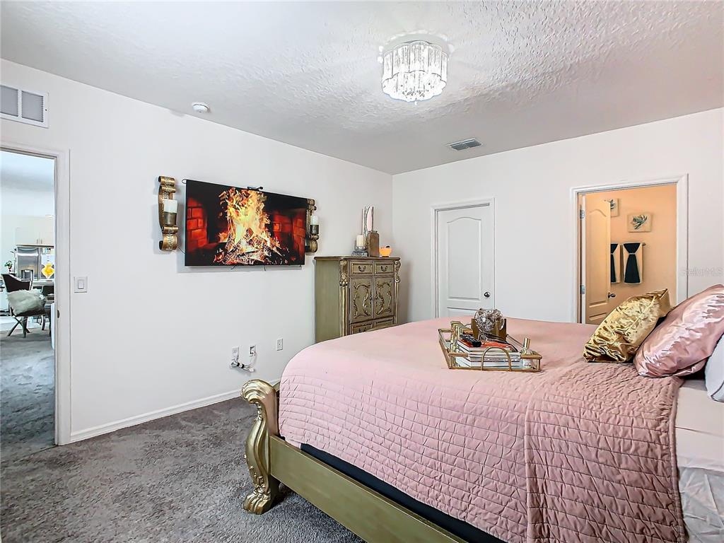 208 Goldenrod Lane Kissimmee, FL 34759 - Photo 18 of 40 a bedroom with a bed and a flat screen tv