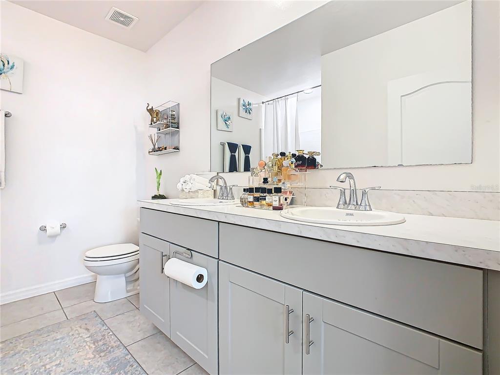 208 Goldenrod Lane Kissimmee, FL 34759 - Photo 26 of 40 a bathroom with a sink toilet and mirror