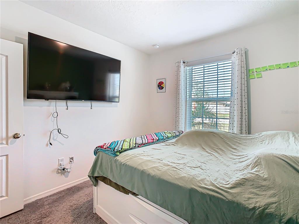208 Goldenrod Lane Kissimmee, FL 34759 - Photo 31 of 40 a bedroom with a bed and a flat screen tv