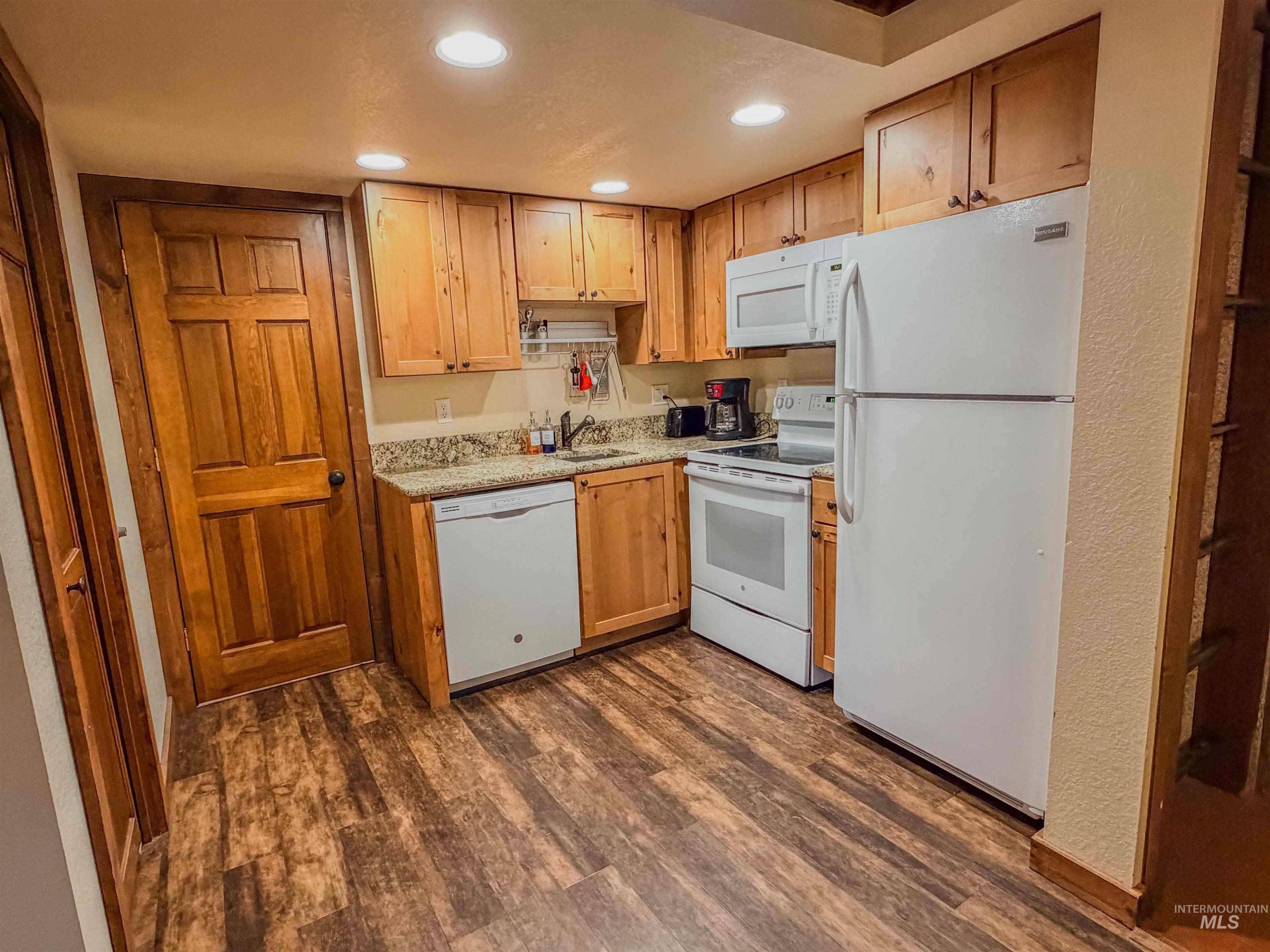 1607 Davis Avenue, Unit C6 McCall, ID 83638 - Photo 11 of 30 Kitchen featuring white appliances, recessed lighting, dark wood-style flooring, and light stone countertops