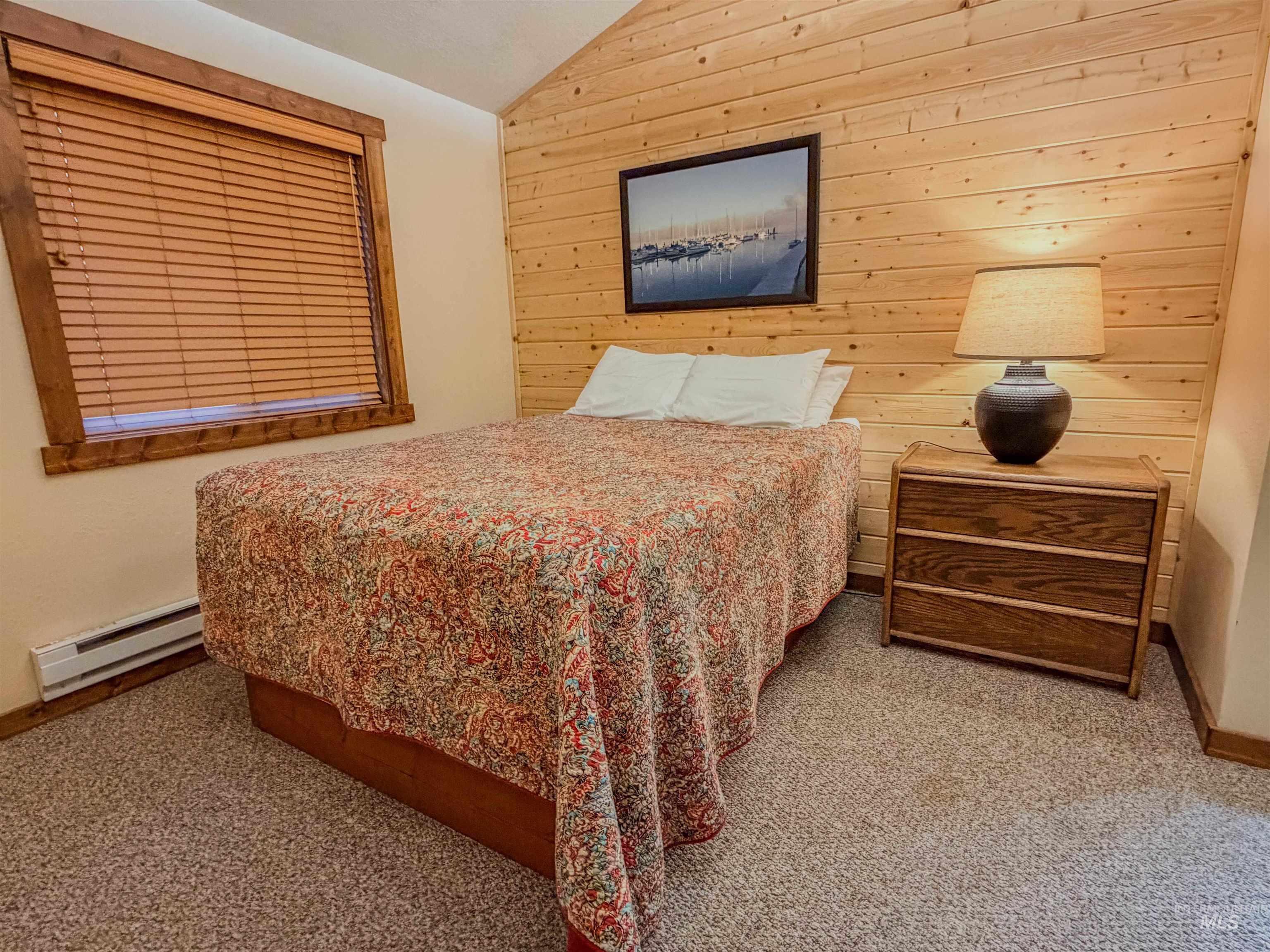 1607 Davis Avenue, Unit C6 McCall, ID 83638 - Photo 13 of 30 Carpeted bedroom with wooden walls, lofted ceiling, and baseboard heating
