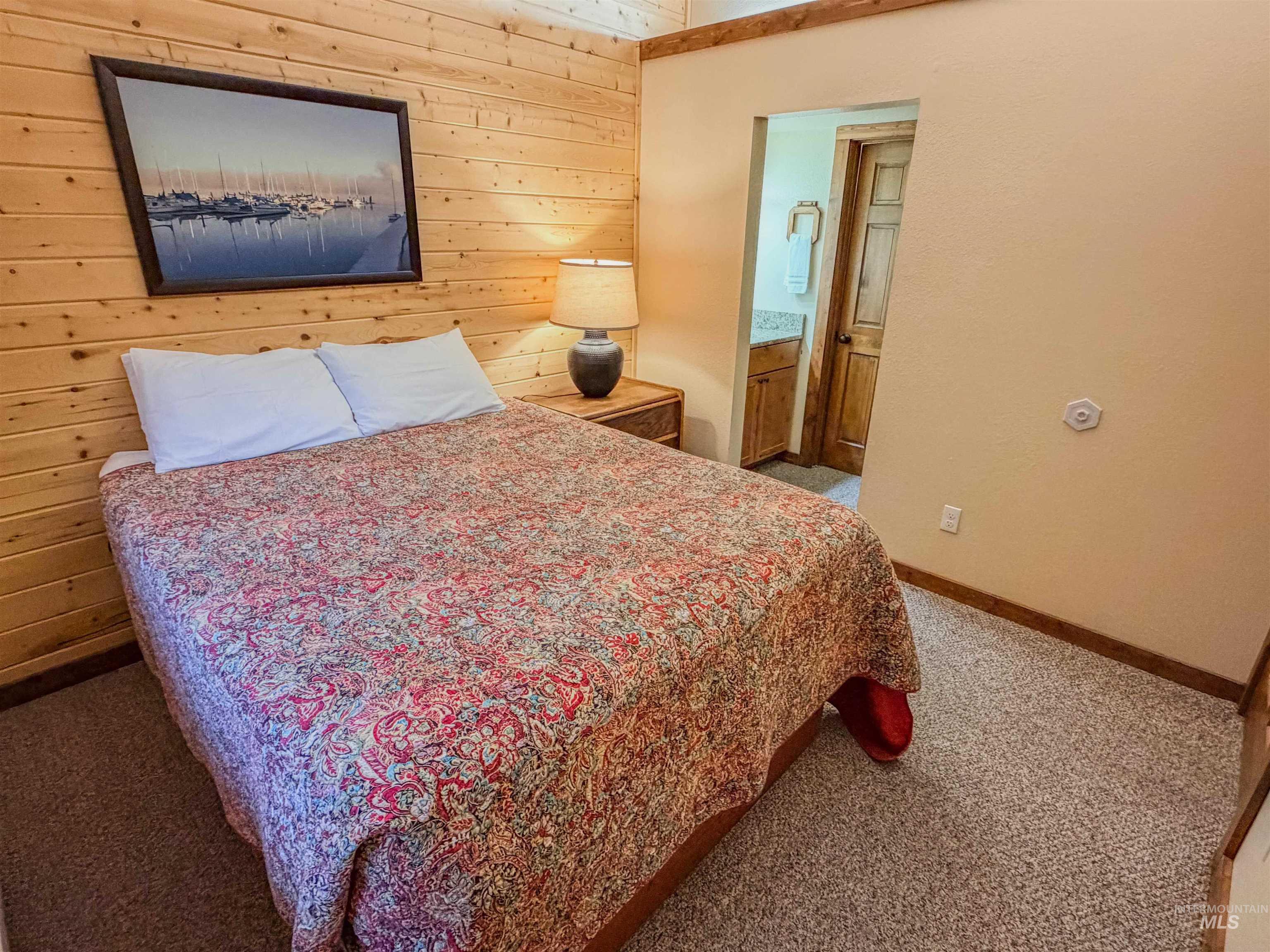 1607 Davis Avenue, Unit C6 McCall, ID 83638 - Photo 14 of 30 Bedroom with wood walls, light colored carpet, and ensuite bathroom