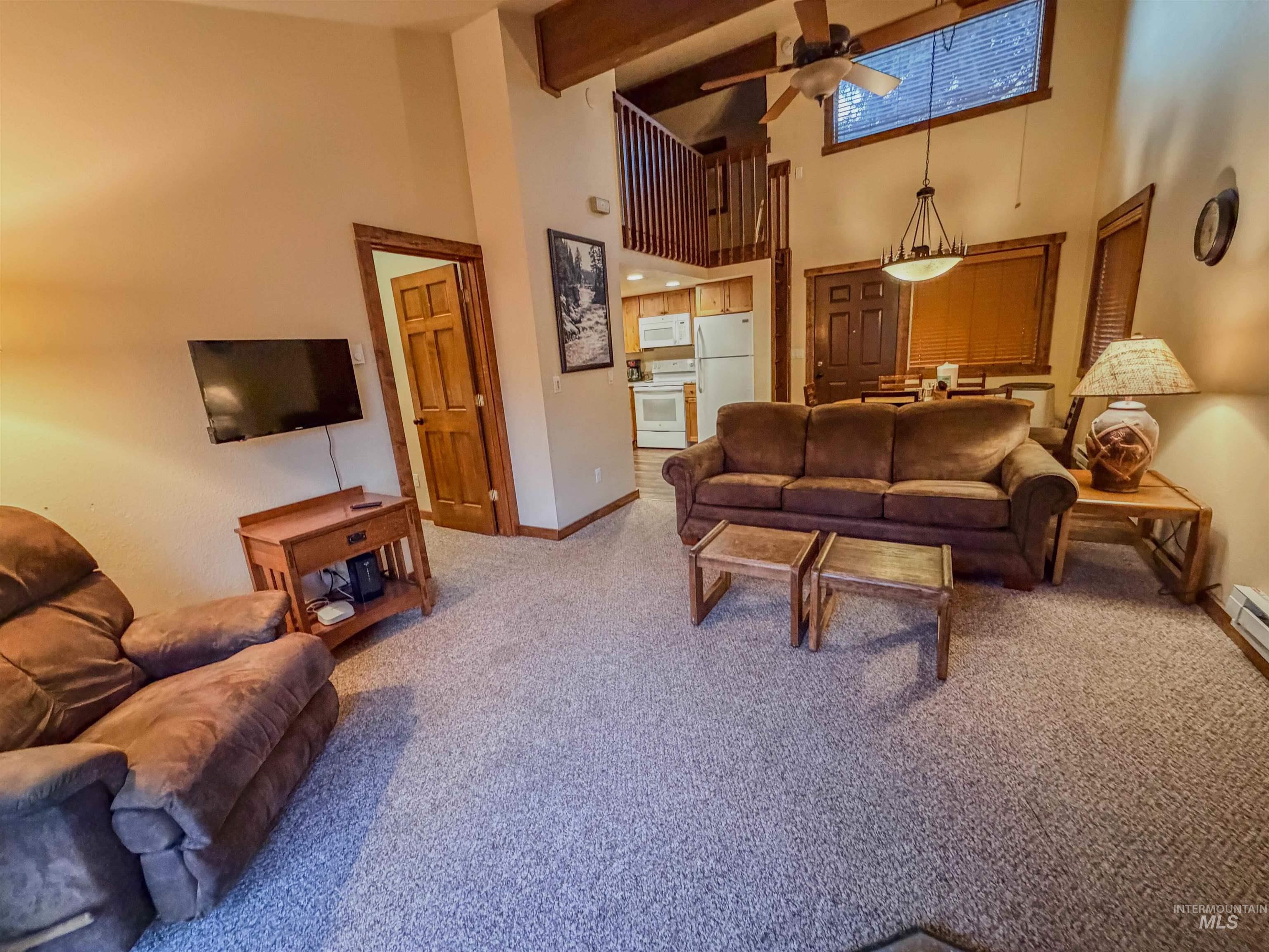 1607 Davis Avenue, Unit C6 McCall, ID 83638 - Photo 3 of 30 Carpeted living area with ceiling fan, a high ceiling, and beam ceiling