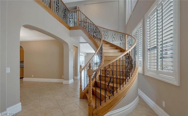 3 Tall Ruff Drive Las Vegas, NV 89148 - Photo 12 of 54 A grand entryway features a curved wooden staircase with intricate wrought iron railings and plantation shutters.