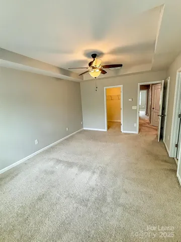 an empty room with a ceiling fan and a window