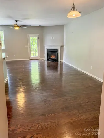 a view of a livingroom with wooden floor fireplace and window