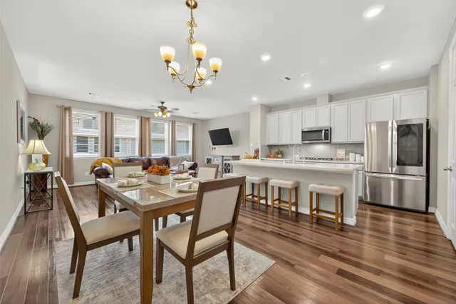 a view of a dining room and livingroom with furniture wooden floor a chandelier
