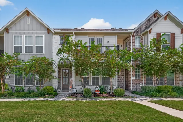 a front view of a house with a yard and trees