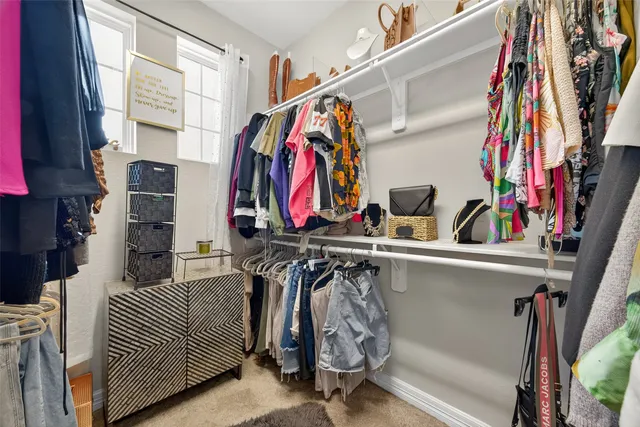 a view of walk in closet with clothes and shoes