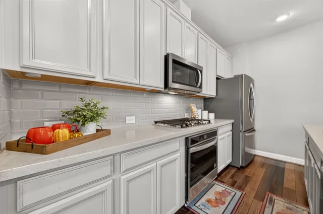 a kitchen with white cabinets and stainless steel appliances