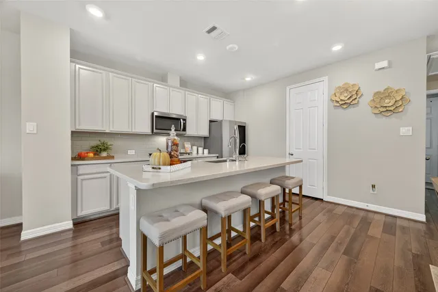 a kitchen with cabinets and wooden floor