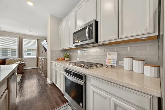 a kitchen with stainless steel appliances granite countertop a stove a microwave and a refrigerator