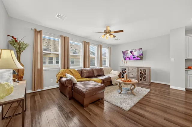 a living room with furniture and a wooden floor