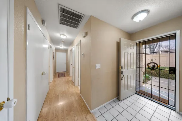 a view of a hallway with wooden floor and staircase